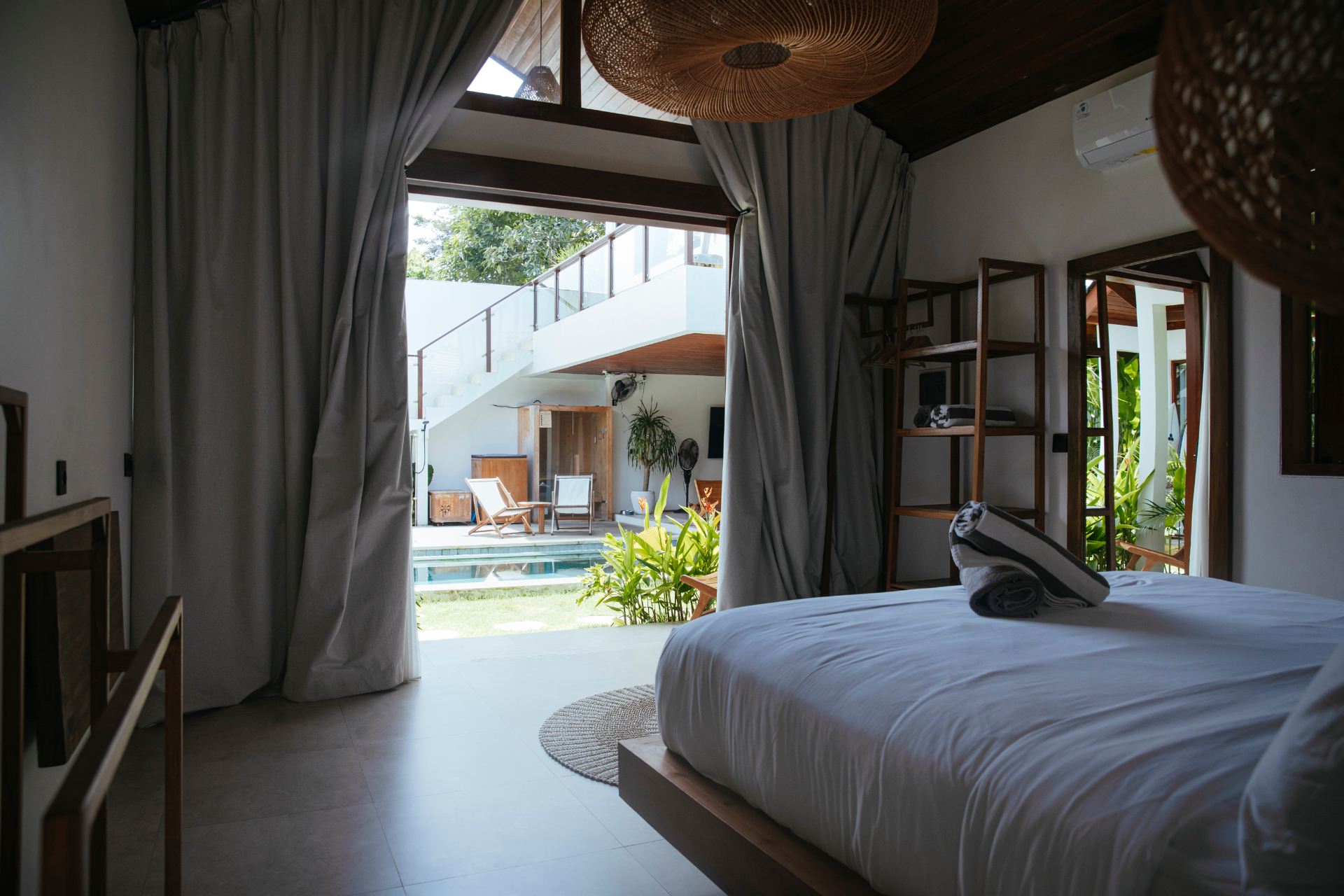 Bedroom opening to the shared pool and sauna deck at Suara Ombak